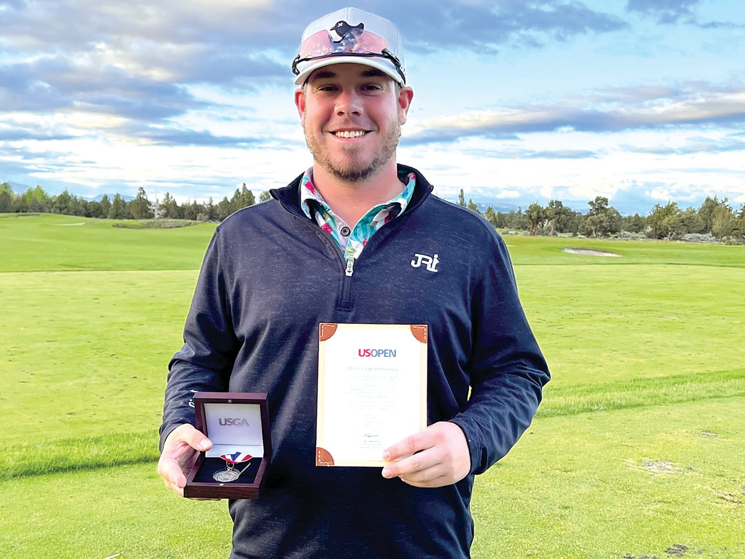 Brady Calkins poses with his U.S. Open qualifying letter at Pronghorn Resort in Bend, Oregon, after finishing tied for first in a 36-hole tournament qualifier.